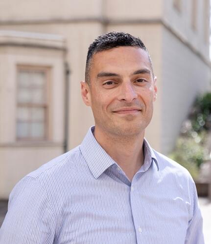 headshot of professor john alba cutler smiling at camera